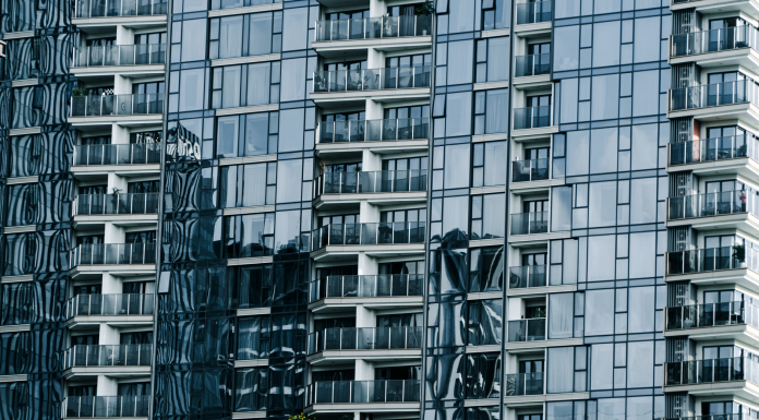 High-rise building with glass facade reflecting surroundings.