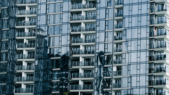 High-rise building with glass facade reflecting surroundings.