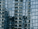 High-rise building with glass facade reflecting surroundings.