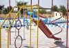 Vibrant playground with slides and swings in outdoor park setting.