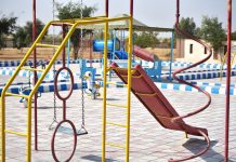 BREAKING: Virginia Avenue Park Reopens With New Playground Vibrant playground with slides and swings in outdoor park setting.