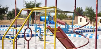 Vibrant playground with slides and swings in outdoor park setting.