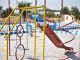 BREAKING: Virginia Avenue Park Reopens With New Playground Vibrant playground with slides and swings in outdoor park setting.