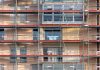 Scaffolding covers an urban building facade, capturing a construction site in detail.