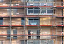 Scaffolding covers an urban building facade, capturing a construction site in detail.