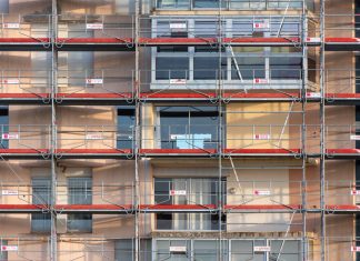 Scaffolding covers an urban building facade, capturing a construction site in detail.