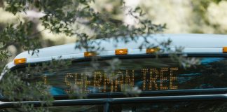 Bus Rapid Transit Meeting Set for Sept. 23 in Jersey City A public bus with a digital sign indicating Sherman Tree destination, amidst greenery.