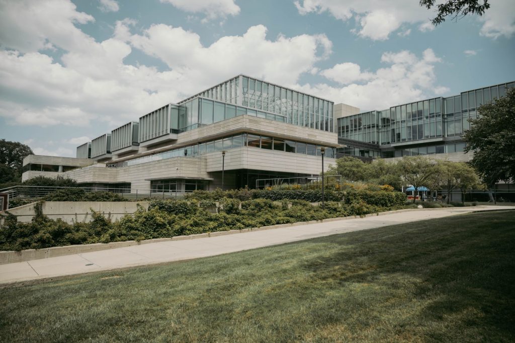 Contemporary glass and concrete university building with lush greenery in Chicago, USA.