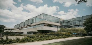 Contemporary glass and concrete university building with lush greenery in Chicago, USA.