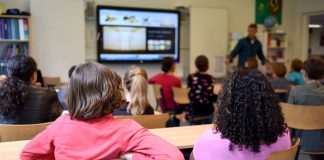 Cómo Inscribir a tu Hijo en las Escuelas de Newark en 2026: Guía Paso a Paso Students attentively watching a lesson on a smart board in a colorful Dutch classroom.