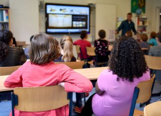 Cómo Inscribir a tu Hijo en las Escuelas de Newark en 2026: Guía Paso a Paso Students attentively watching a lesson on a smart board in a colorful Dutch classroom.