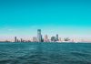 Panoramic view of Manhattan skyline with modern skyscrapers under a clear blue sky.