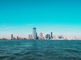 Panoramic view of Manhattan skyline with modern skyscrapers under a clear blue sky.