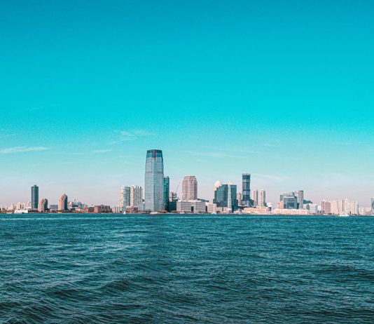 Panoramic view of Manhattan skyline with modern skyscrapers under a clear blue sky.