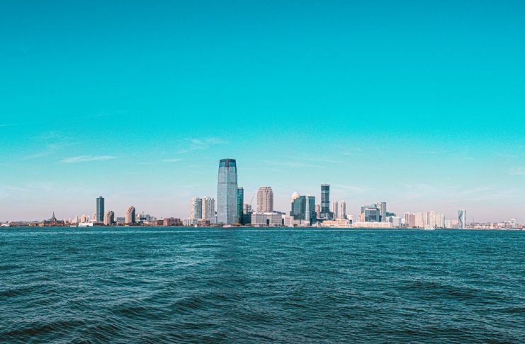 Panoramic view of Manhattan skyline with modern skyscrapers under a clear blue sky.