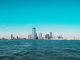 Cosas Gratis Que Hacer en Jersey City en 2026: Guía Completa de Aventuras Sin Gastar un Dólar Panoramic view of Manhattan skyline with modern skyscrapers under a clear blue sky.