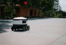Delivery Robots Rolling Into Hoboken This September A sleek autonomous food delivery robot navigates a sunny urban landscape, showcasing modern innovation.