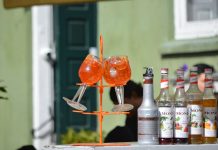 Colorful Aperol Spritz and Monin syrups on display outdoors, perfect for summer cocktails.