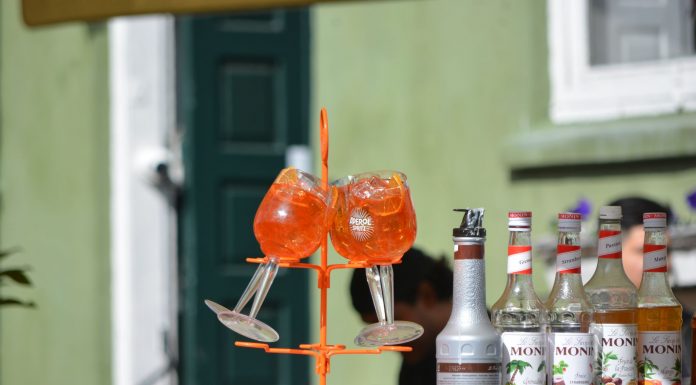 Colorful Aperol Spritz and Monin syrups on display outdoors, perfect for summer cocktails.