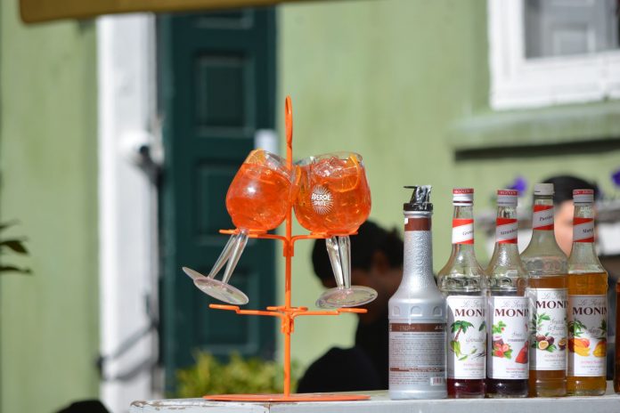 halifax-in-hoboken-serves-aperol-spritz-trees-for- Colorful Aperol Spritz and Monin syrups on display outdoors, perfect for summer cocktails.