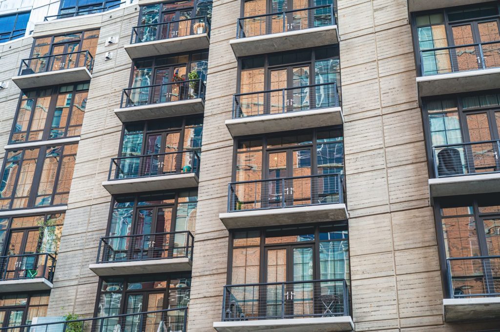 Contemporary apartment building exterior with concrete facade and glass balconies.