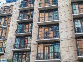 Contemporary apartment building exterior with concrete facade and glass balconies.