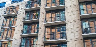 Contemporary apartment building exterior with concrete facade and glass balconies.