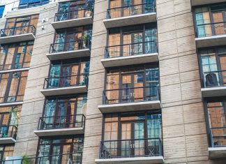 Contemporary apartment building exterior with concrete facade and glass balconies.