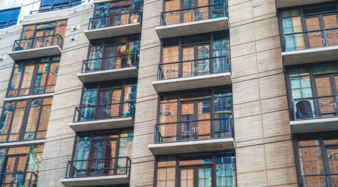 Contemporary apartment building exterior with concrete facade and glass balconies.