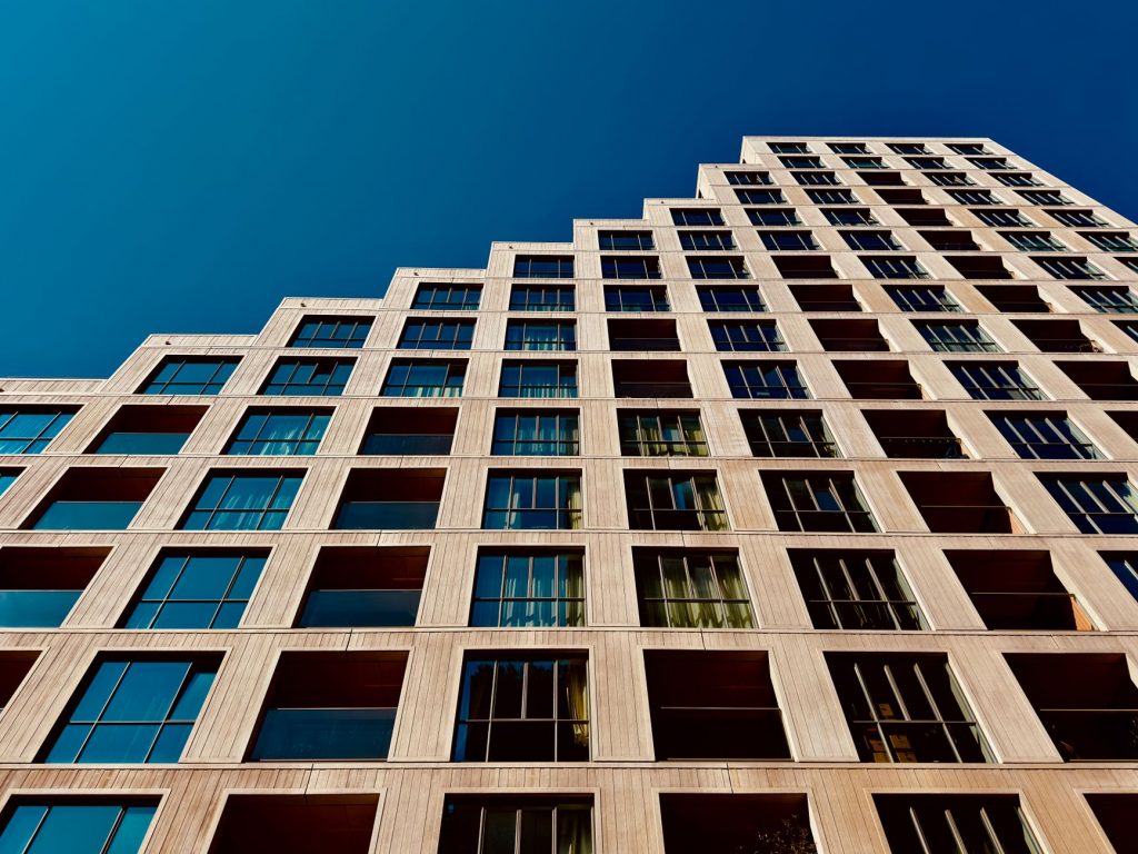 A modern high-rise building in Eindhoven, Netherlands with a clear blue sky backdrop.