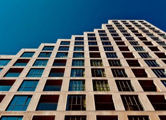 A modern high-rise building in Eindhoven, Netherlands with a clear blue sky backdrop.