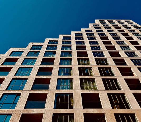 A modern high-rise building in Eindhoven, Netherlands with a clear blue sky backdrop.