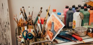 Colorful art studio corner with brushes, paints, and a painted canvas. Ideal for creative inspiration.