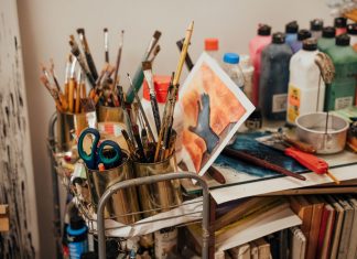 Colorful art studio corner with brushes, paints, and a painted canvas. Ideal for creative inspiration.