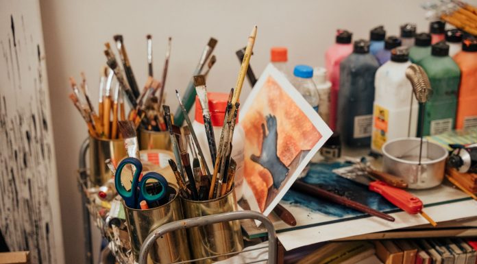 Colorful art studio corner with brushes, paints, and a painted canvas. Ideal for creative inspiration.