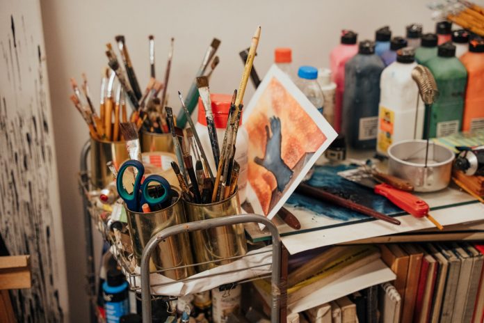 hudson-county-opens-applications-for-arts-and-hist Colorful art studio corner with brushes, paints, and a painted canvas. Ideal for creative inspiration.