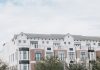 A stylish, multi-story luxury apartment building with a contemporary facade against a clear sky.