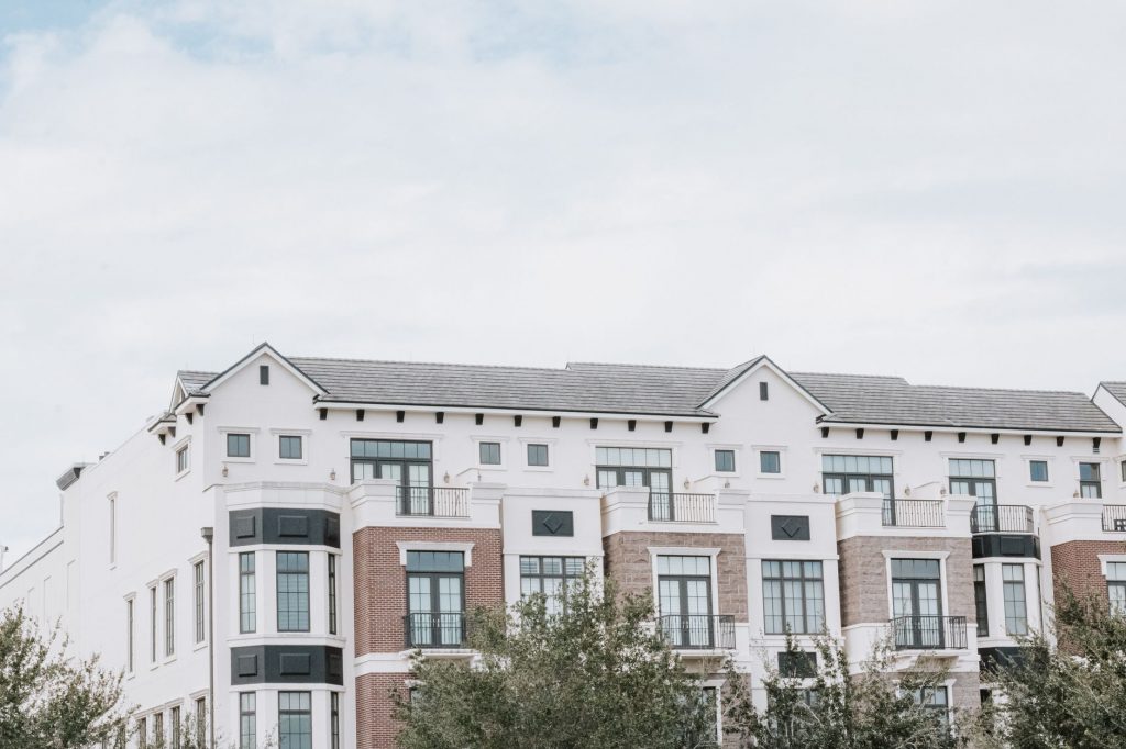 A stylish, multi-story luxury apartment building with a contemporary facade against a clear sky.