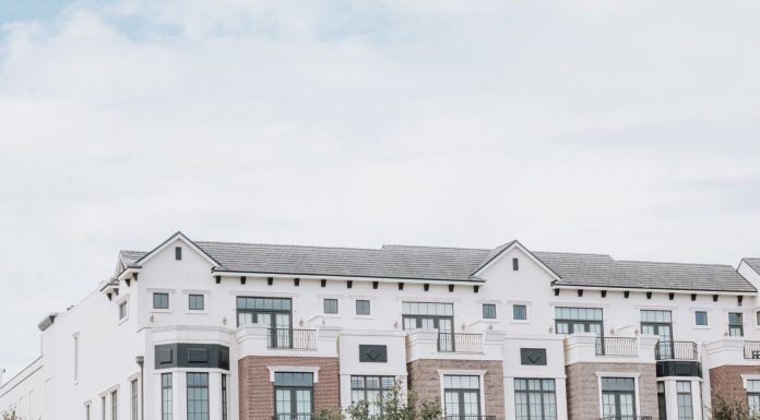 A stylish, multi-story luxury apartment building with a contemporary facade against a clear sky.