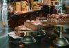 Tempting chocolate cakes with decorations on display in a cozy cafe setting.