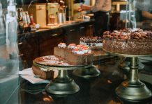 Tempting chocolate cakes with decorations on display in a cozy cafe setting.