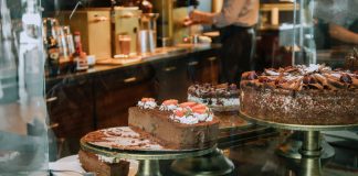 Tempting chocolate cakes with decorations on display in a cozy cafe setting.