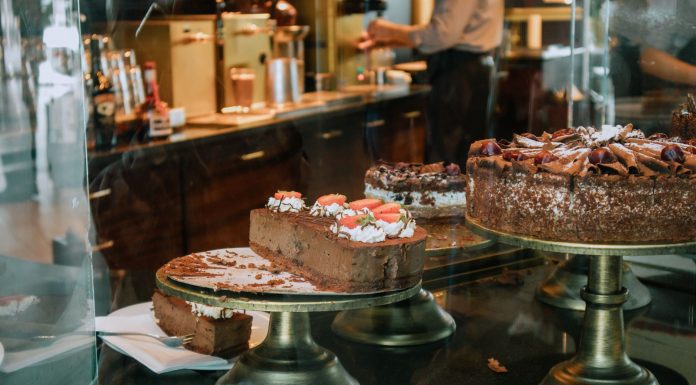 Tempting chocolate cakes with decorations on display in a cozy cafe setting.