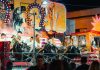 People enjoying a vibrant bull ride at an outdoor funfair at night.