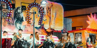 People enjoying a vibrant bull ride at an outdoor funfair at night.