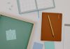 Top view of office supplies including a planner, pencil, and vote message for creative workspaces.