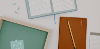 Top view of office supplies including a planner, pencil, and vote message for creative workspaces.