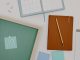 Jersey City Board to Vote on New McNair, Infinity Admissions Top view of office supplies including a planner, pencil, and vote message for creative workspaces.