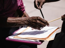 Jersey City Council Outraged Over 2025 Audit Findings: ‘This Is Criminal!’ Close-up of hands exchanging documents with pens outdoors. Business agreement concept.