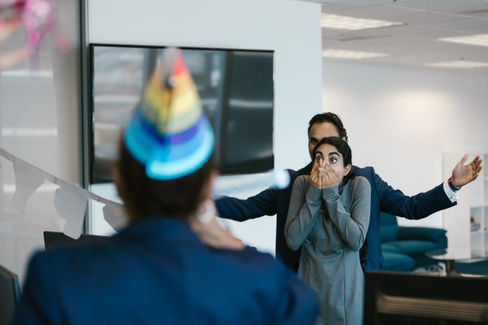 jersey-city-cultural-affairs-director-christine-go A surprised woman at an office party celebration with colleagues.